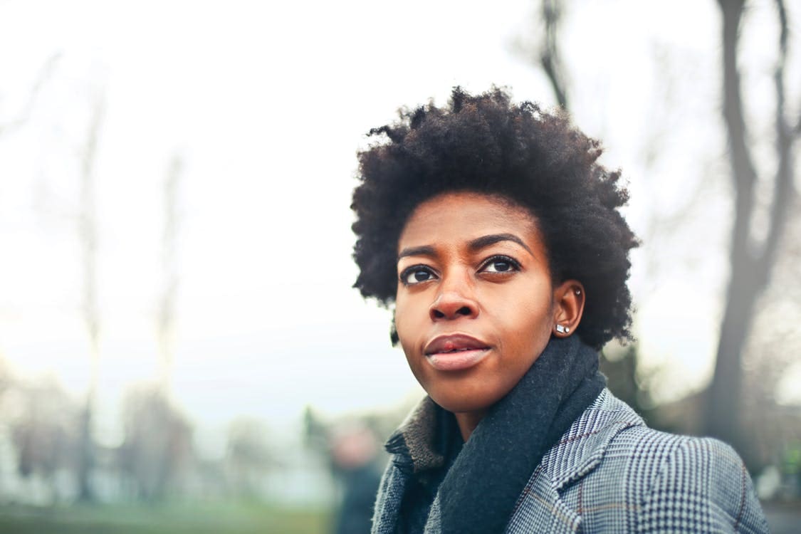 Woman with short hair looks out into the distance.