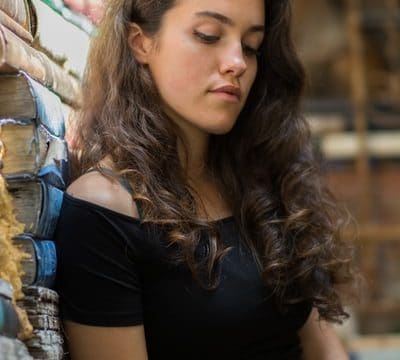 Young woman with long curl hair looking down