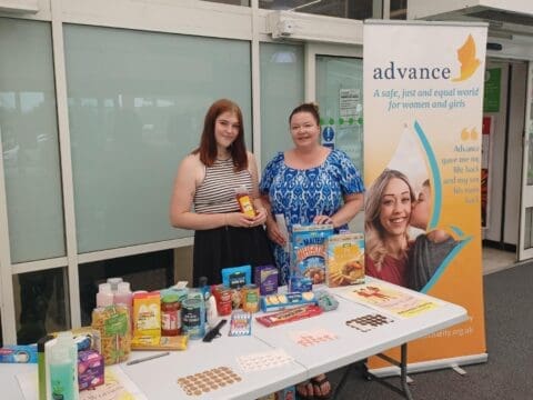 Advance staff smiling at a donation table outside of Asda
