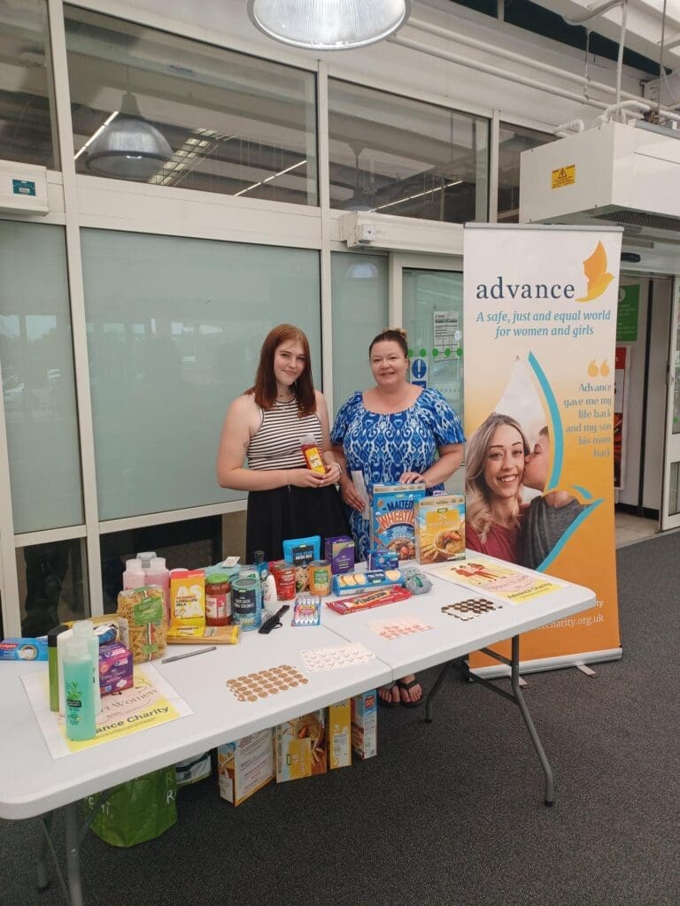 Advance staff smiling at a donation table outside of Asda