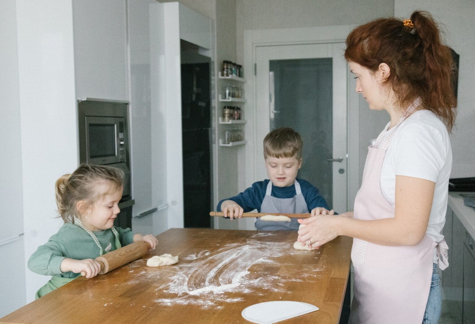 Woman with two children baking with flour.