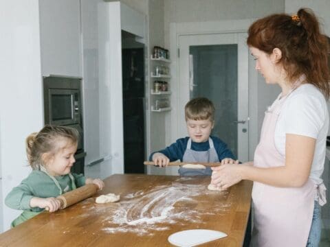 Woman with two children baking with flour.