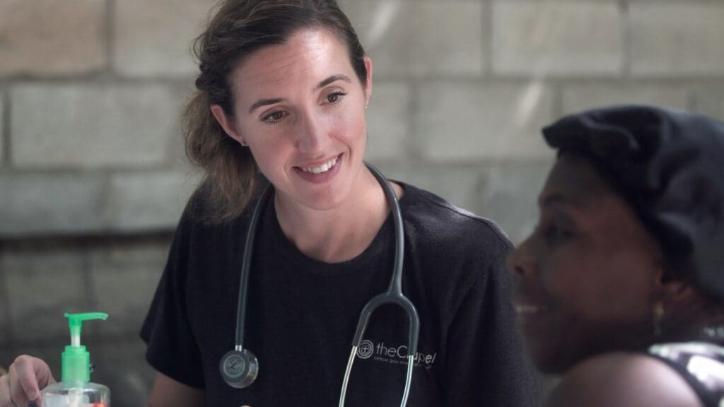 Female health care professional smiles at woman.