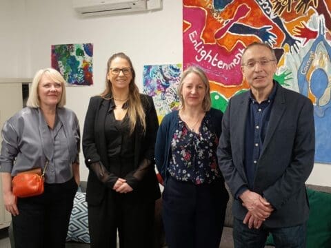 four people standing together smiling. Three women and one man. The man is MP Andy Slaughter.