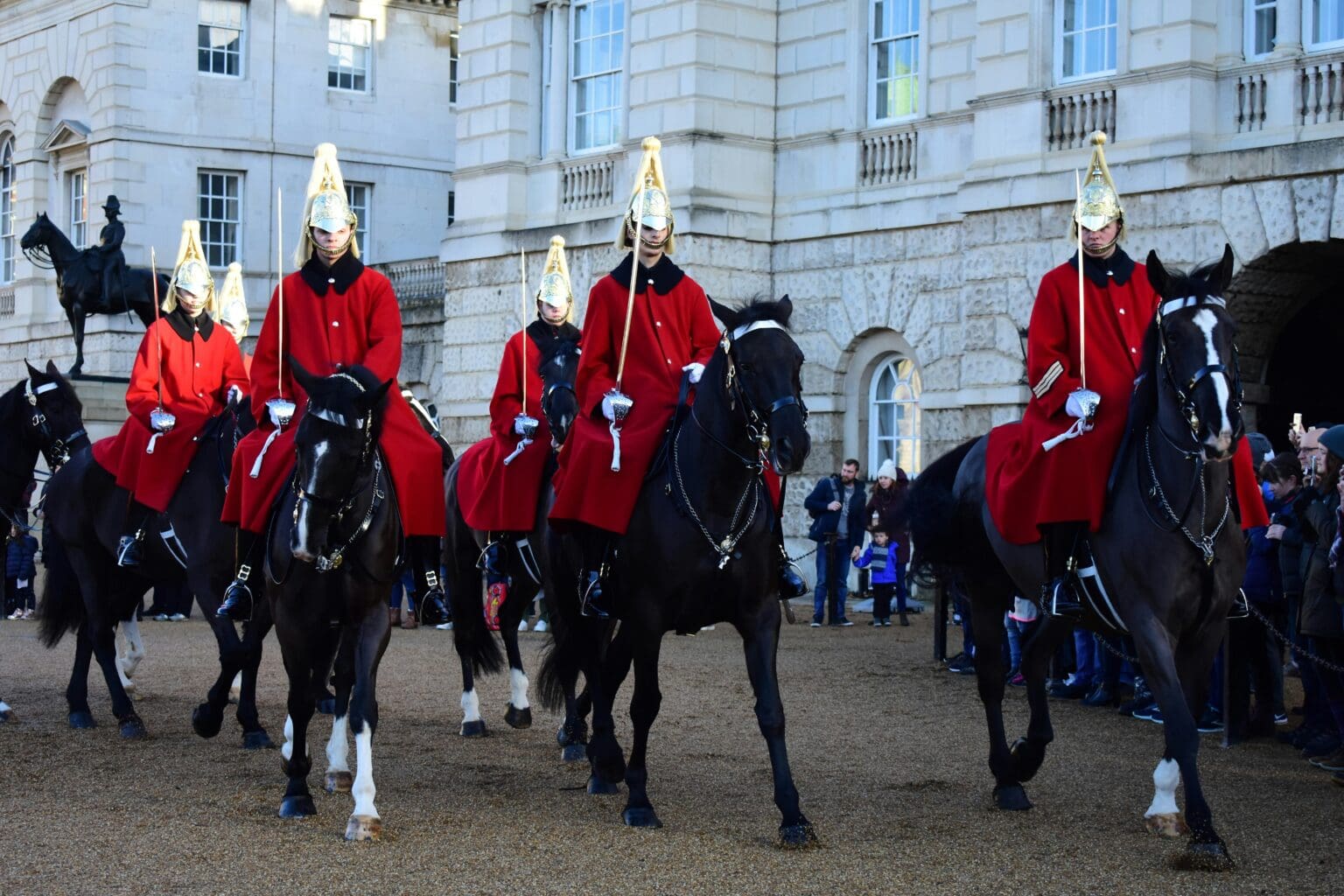A number of kings guard on horses.