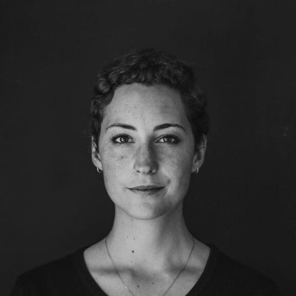 woman with short brown hair, with a slight smile. Portrait shot looking to camera. Black and white